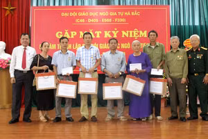Ông Nguyễn Văn Thêm – Phó Giám đốc Sở GD&ĐT (ngoài cùng bên trái) thay mặt ngành Giáo dục tặng quà cho đại diện gia đình các liệt sĩ (Ảnh Minh Thu).