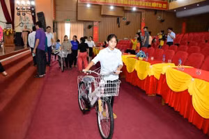 Học sinh nghèo vui mừng bên chiếc xe đạp mới được trao tặng.