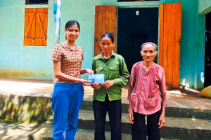 Đại diện Báo GD&TĐ trao tiền do bạn đọc hỗ trợ đến bà Nguyễn Thị Long (mẹ của em Nguyễn Thị Thúy).