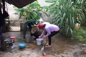 Cán bộ đồn Biên phòng Vĩnh Châu tuyên truyền và giúp người dân vệ sinh các dụng cụ chứa nước.
