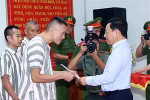 Phó Thủ tướng Thường trực Chính phủ Phạm Bình Minh trao quyết định đặc xá cho các phạm nhân. Ảnh: Phạm Kiên/TTXVN.