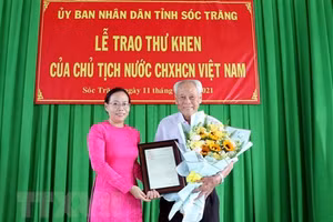 Phó Chủ tịch UBND tỉnh Sóc Trăng Huỳnh Thị Diễm Ngọc trao thư khen của Chủ tịch nước cho ông Trần Cang. Ảnh: TTXVN.
