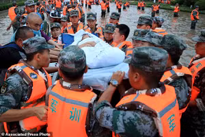 Quân nhân Trung Quốc sơ tán người dân khỏi bệnh viện nơi có khoảng 3.000 người bị mắc kẹt do lũ lụt ở Trịnh Châu, tỉnh Hà Nam, miền trung Trung Quốc.