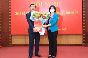 Phó Bí thư Thường trực Thành ủy Nguyễn Thị Tuyến trao quyết định, tặng hoa chức mừng tân Bí thu Huyện ủy Mê Linh Nguyễn Thanh Liêm. Ảnh: ANTĐ