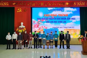 Tiến sĩ Võ Khắc Sơn - Phó Hiệu trưởng Trường Đại học Quảng Bình trao quà Tết cho lưu học sinh Lào.