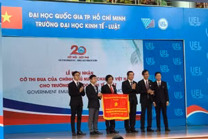 Thứ trưởng Bộ GD&ĐT Nguyễn Văn Phúc (thứ 3 từ phải qua) trao cờ thi đua của Chính phủ tặng Trường ĐH Kinh tế - Luật (ĐHQG TP.HCM)