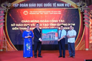 Ông Thái Viết Tường (thứ 2 từ phải qua) tặng bức tranh Chùa Cầu cho lãnh đạo Trường Trường Mầm non-TH-THCS-THPT Nam Việt.