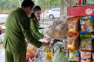 Lực lượng chức năng kiểm tra các ki-ốt kinh doanh bánh, kẹo gần trường học. (Ảnh: Công an TP Vinh)
