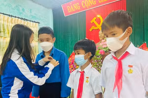Chị Trần Thị Thu - Bí thư Tỉnh đoàn Quảng Trị trao huy hiệu "Tuổi trẻ dũng cảm" cho 3 học sinh (Ảnh: Lập Xuân)