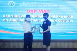 Sinh viên nhận quà hỗ trợ của Trường ĐH Mở Hà Nội từ Phó Hiệu trưởng Nguyễn Minh Phương. Ảnh: NTCC
