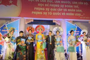 TS Trường Tiến Tùng - Hiệu trưởng Trường ĐH Mở Hà Nội trai giải nhất cho 2 thí sinh phần trình diễn trang phục áo dài.
