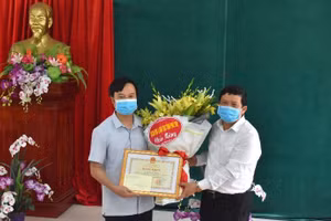 Ông Nguyễn Văn Mạnh - Giám đốc Sở GD&ĐT Phú Thọ trao bằng khen của Bộ trưởng Bộ Giáo dục và Đào tạo cho thầy Phùng Anh Tuấn. Ảnh: Hà Trang