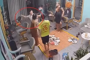 Phó trưởng Công an phường Sông Bằng (mặc áo sơ mi trắng) tát mạnh vào mặt cô gái trong quán tóc được camera an ninh ghi lại. 