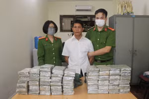Đối tượng Vàng A Súa cùng tang vật 98 bánh heroin tại cơ quan điều tra. Ảnh: Công an Điện Biên.