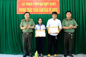 Thượng tá Lê Văn Thích, Phó trưởng Công an TP Long Xuyên và Thượng tá Nguyễn Sơn Hà, Phó trưởng Phòng Xây dựng phong trào bảo vệ ANTQ Công an tỉnh An Giang trao thưởng cho anh Trương Thanh An và em Lý Hải Yến. Ảnh: CAAG.