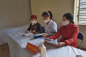 Cán bộ Trạm Y tế lưu động xã Quốc Tuấn, huyện An Dương ghi sổ theo dõi sức khỏe của bệnh nhân.