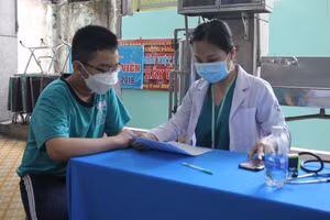 Nhân viên y tế tư vấn cho học sinh TPHCM trước khi tiêm vắc xin Covid-19.