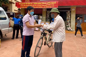 Ông Thịnh (bên phải) gửi tiền tiết kiệm cho Ban vận động kêu gọi hỗ trợ huyện Nậm Pồ. Ảnh: Điêu Bình Dương