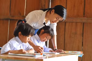 Giáo viên hướng dẫn học sinh tập viết. 