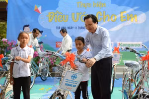Bộ trưởng Phùng Xuân Nhạ trao tặng xe đạp cho học sinh tại Trà Vinh. Ảnh: Thế Đại