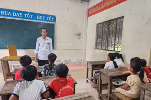 Ông Danh Nghe dạy học cho các em học sinh