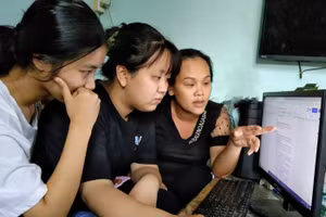 Cô Vy (ngoài cùng bìa phải) chỉ bài cho học sinh. 