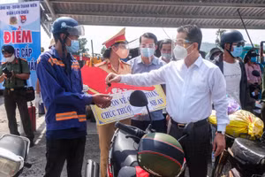 Ông Nguyễn Văn Quảng - Bí thư Thành ủy Đà Nẵng (áo sơ mi trắng) trao tặng xe máy cho người dân khó khăn trên đường đi về quê. 