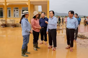 Giáo viên trường Tiểu học Hàm Ninh báo cáo Bộ trưởng Phùng Xuân Nhạ về tình hình lũ lụt và những thiệt hại mà nhà trường phải gánh chịu trong đợt lũ lịch sử vừa qua. Ảnh: Thế Đại