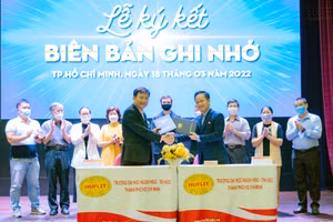 Đại diện HUFLIT và MoMo trao văn bản ký kết.