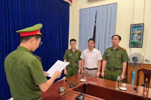Lực lượng chức năng đọc quyết định bắt tạm giam Lê Văn Kỳ.