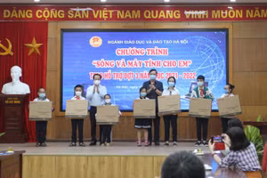 Lãnh đạo Sở GD&ĐT Hà Nội trao máy tính, thiết bị cho đại diện các em học sinh.