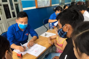 Một số phụ huynh tại Quận 12 làm thủ tục nhập học vào lớp 1 cho con sáng ngày 29/8. Ảnh minh hoạ N.Loan