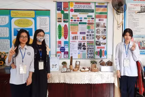 Hai nữ sinh cùng cô giáo Hương trong gian trưng bày sản phẩm.