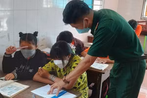 Thầy giáo Trần Văn Cảnh hướng dẫn học sinh học bài.
