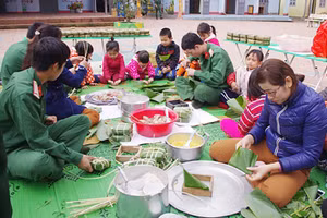 Chiến sĩ và giáo viên Trường Mầm non Núa Ngam (Điện Biên) gói bánh chưng tặng học sinh và hộ nghèo trên địa bàn.