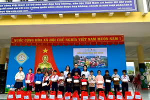 Các em học sinh có hoàn cảnh khó khăn được tặng quà và học bổng. Ảnh: H.V