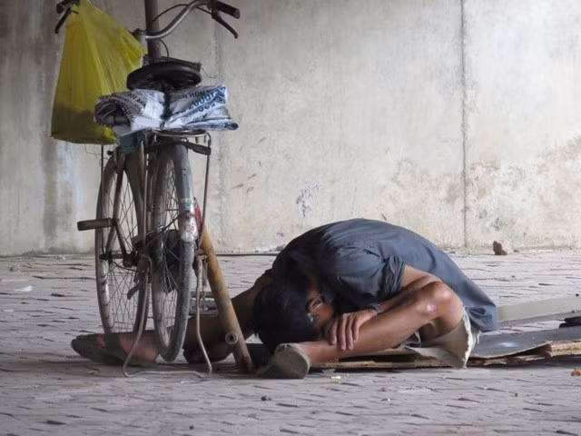 Một đối tượng nghiện phê ma túy đang gục đầu xuống đất ngay dưới gầm cầu đường bộ Tam Bạc.