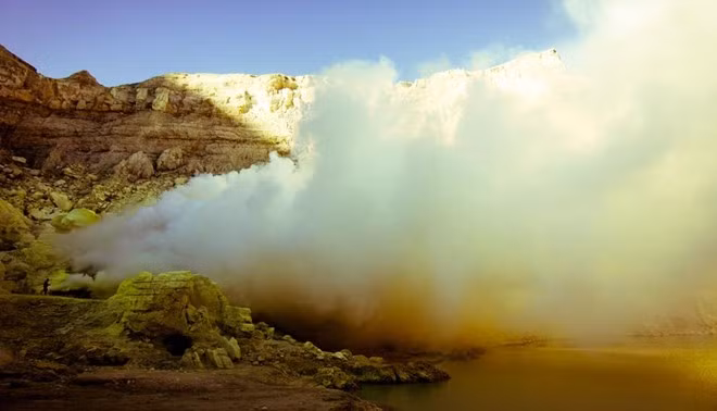 Miệng núi lửa Kawah Ijen chứa một hồ nước axit màu xanh ngọc rộng khoảng một km, liên tục rò rỉ khí lưu huỳnh. Ảnh: BBC.