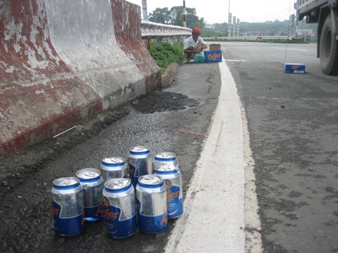Người dân giúp tài xế thu gom lại gọn gàng số bia bị rơi xuống đường.
