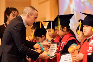 Ông Jonathan Bird, Giám đốc Đào tạo ILA Việt Nam, trao học bổng cho học sinh.