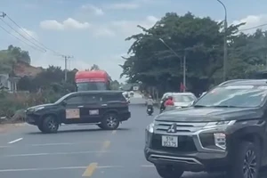 2 xe ô tô án ngữ tuyến quốc lộ, buộc các phương tiện khác phải dừng lại nhường đường.
