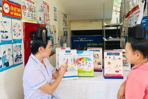 Cán bộ ở trạm y tế tư vấn cho người dân. Ảnh BSL