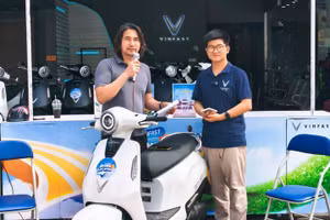 Anh Trịnh Huy Hiệu (bên trái) đang giới thiệu mẫu xe máy điện Evo Grand Lite cho khách hàng.