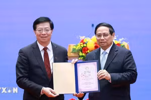 Ông Khưu Dũng, Bí thư Đảng ủy Đại học Thanh Hoa, Trung Quốc trao tặng Thủ tướng Phạm Minh Chính danh hiệu "Giáo sư danh dự Đại học Thanh Hoa". (Ảnh: Dương Giang/TTXVN).