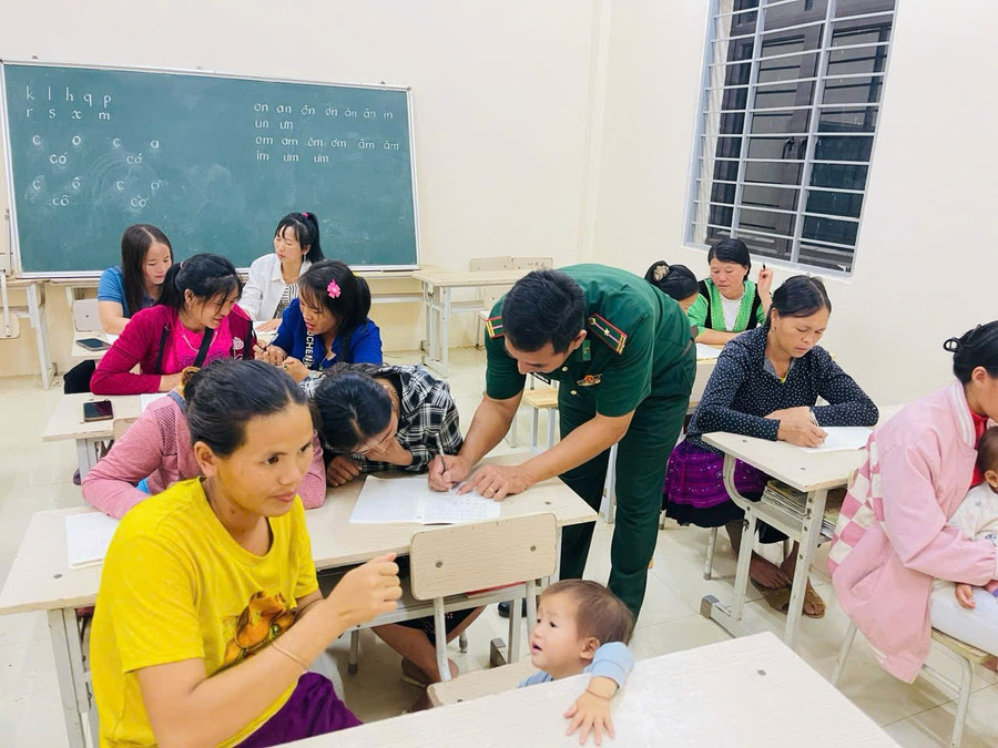 Thầy giáo quân hàm xanh tận tình hướng dẫn từng nét chữ đầu tiên cho học trò.