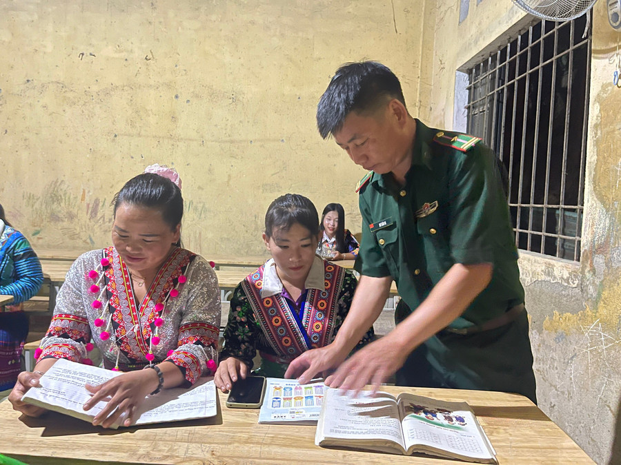 Thầy giáo Hơ Văn Di tận tình hướng dẫn bà con tập đọc.