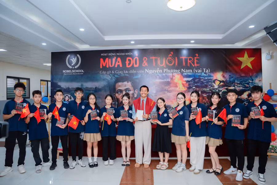 Diễn viên Phương Nam trao tặng sách "Mưa đỏ" cho học sinh.