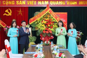 Phó Chủ tịch HĐND TP Hà Nội Phạm Quí Tiên tặng hoa và trao bằng công nhận cho Ban Giám hiệu Trường Tiểu học Nguyễn Tri Phương. Ảnh: TT