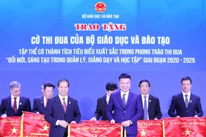 Nhà báo Triệu Ngọc Lâm - Tổng Biên tập Báo Giáo dục và Thời đại thay mặt tập thể Báo nhận Cờ thi đua từ Bộ trưởng Nguyễn Kim Sơn. Ảnh: Lê Cường.
