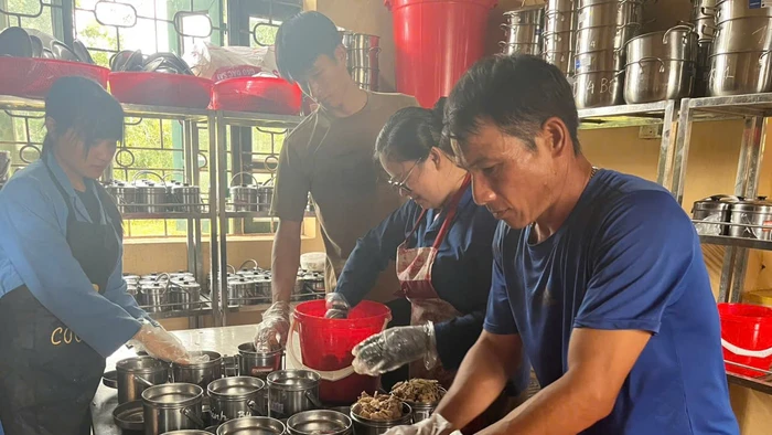 Nhân viên nhà bếp Trường PTDTNT THPT Mường Nhé chia thức ăn cho học sinh.